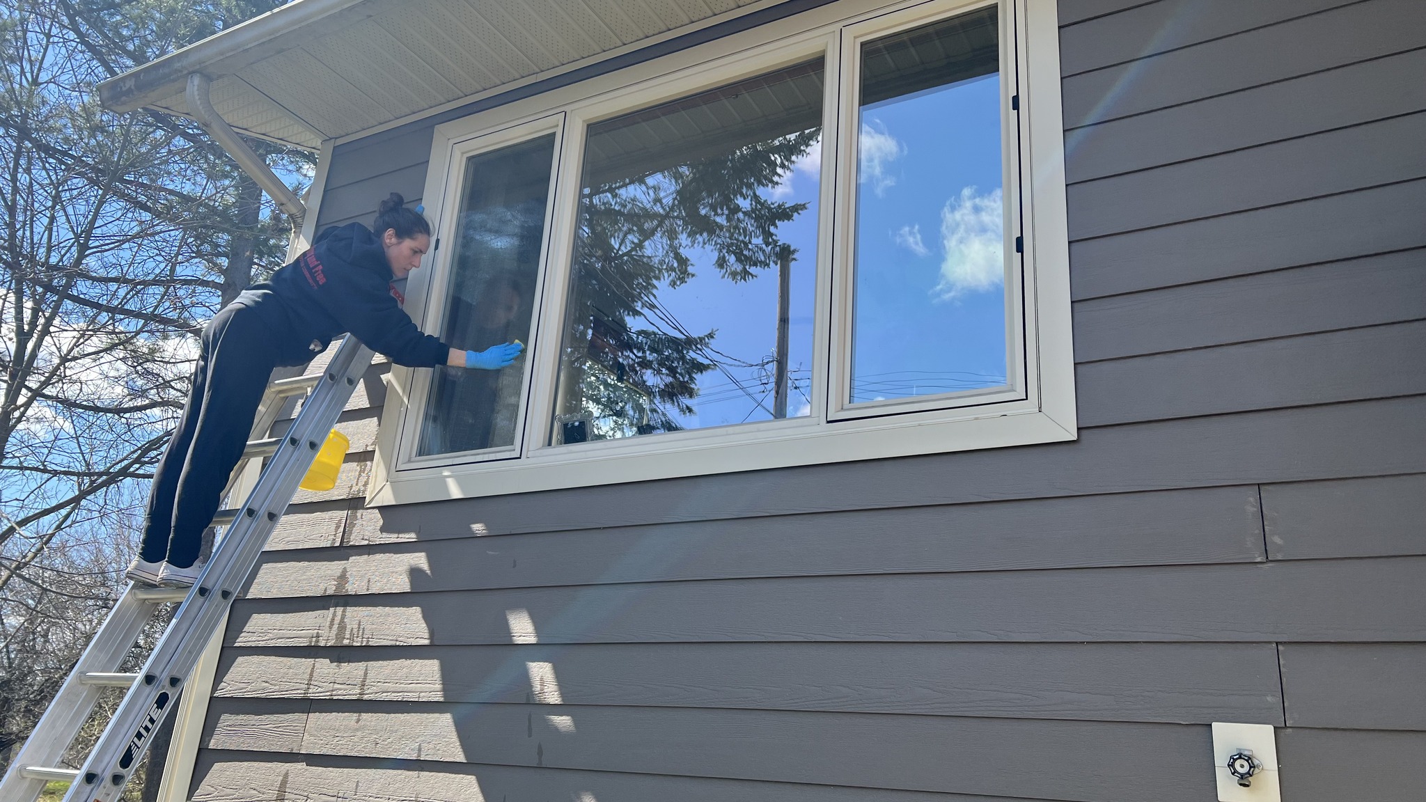 Exterior window cleaning on ladder